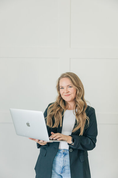 Modern branding session for female entrepreneurs by Zoe Evans Photography, featuring a business owner with laptop in bright studio.