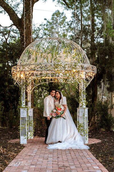 Bride and groom walking hand-in-hand near a lake after their wedding ceremony