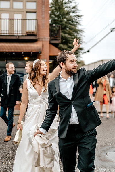 couple walking down the street and waving