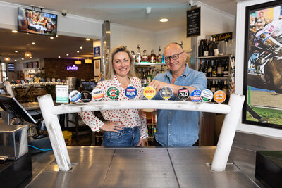 The owners of the Royal Hotel Wyong standing behind the bar to promote a theatre show that landlord Marney McQueen was starring in.
