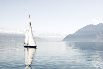 sailboat on water with mountains in back