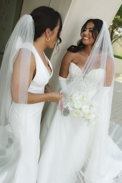 two brides smiling at each other outside of the Kauffman in Kansas City