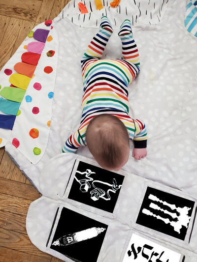 baby peering at Jewish contrast cards inserted into Lovevery playmat