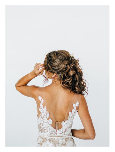 Back of bride wearing a sleeveless white lace wedding dress