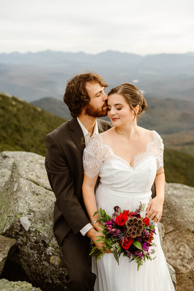 A couple stands in the Shenandoah National Park mountains at sunset after getting married.