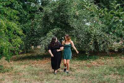 Eugene wedding planners Clarae and Taressa link arms and smile while walking together. 