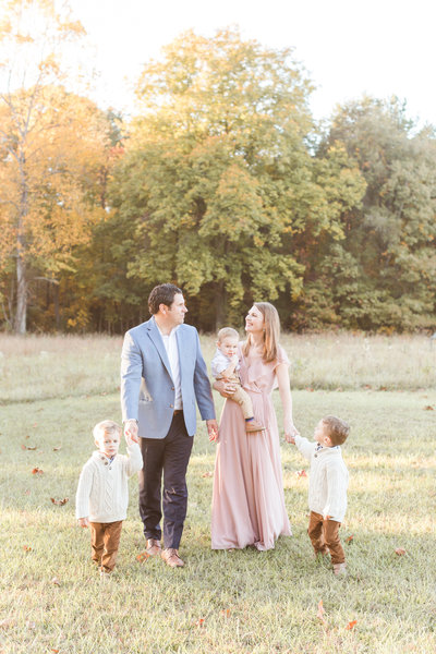 A family walking outside holding hands in the Fall by Virginia Family Photographer