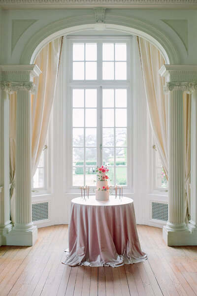 Ballroom wedding cake vignette with a blush velvet table linen and intricate sugar flower accents