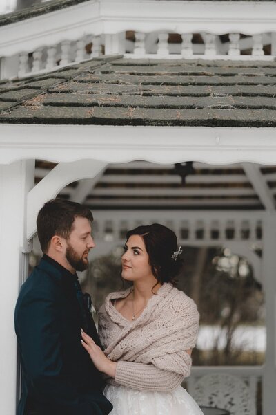 Wedding couple looking at each other in gazebo at The Norland Historic Estate in Lethbridge