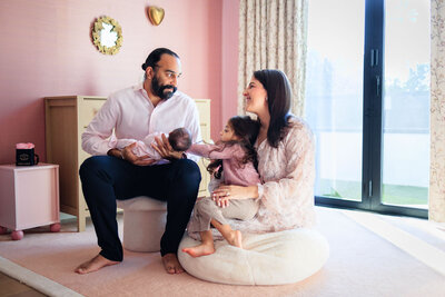 Mom, dad, and toddler celebrate their baby's first birthday with cupcakes and party hats, taken during a Los Angeles Family photography session.