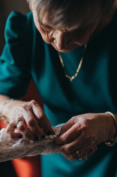 Mother of bride helps with bracelet clasp