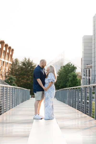 engaged couple posing on a walking bridge in Chattanooga in the spring
