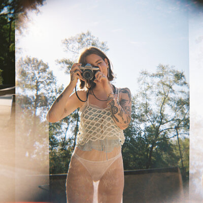 Film photo of woman holding up a film camera to her eye