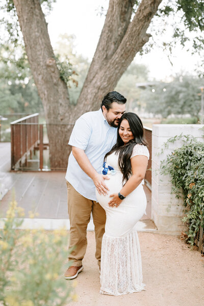 Husband and Wife resting heads together at their maternity shoot at the San Antonio Pearl