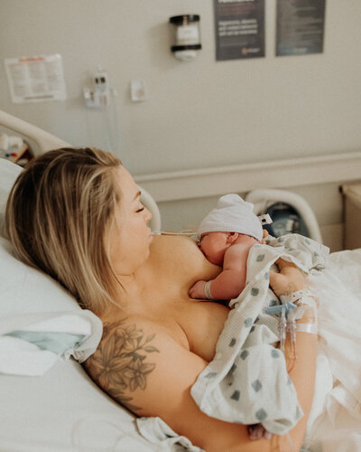 Mother holding up her newborn baby in hospital, photo taken by Indianapolis Newborn Photographer