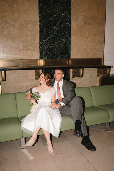 NYC city hall couple with vintage armani suit and custom dress on green couch