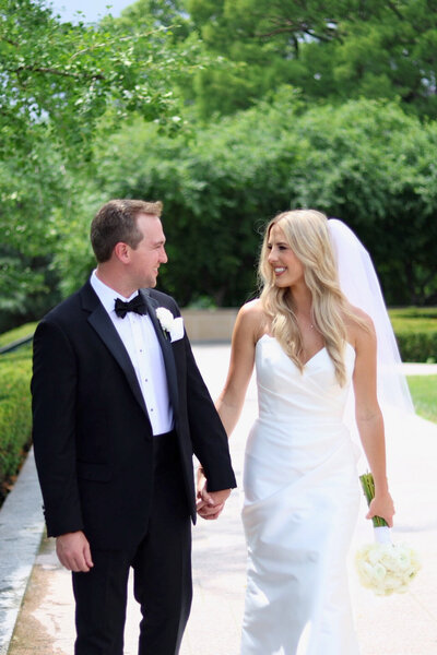 Bride and groom walking and holding hands at Nelson Atkins Museum