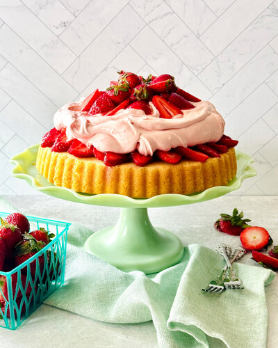 cake topped with fresh strawberries and whipped cream