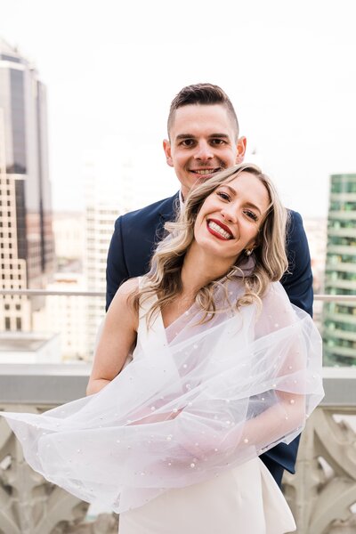Bride and groom smile for wedding portraits at Hotel Kansas City's Starlight Terrace