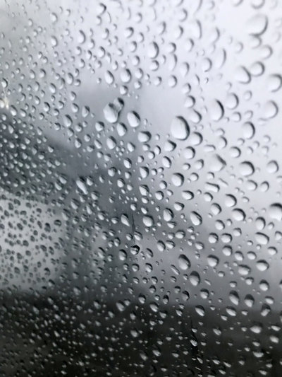 view of brooklyn bridge with rain drops on the windshield