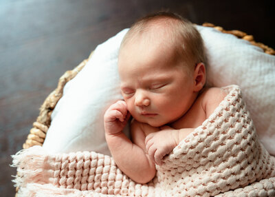 Natural light newborn on pillow with blanket