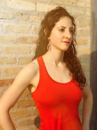 A client wearing a red tank top and lipstick with her hands on her hips