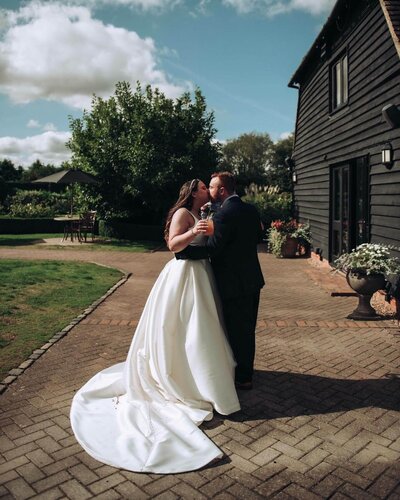 Bride and groom kissing after getting married at The Old Kent Barn