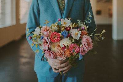 Bride and groom running down park path