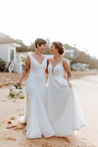 Two women in wedding dresses getting married on the beach