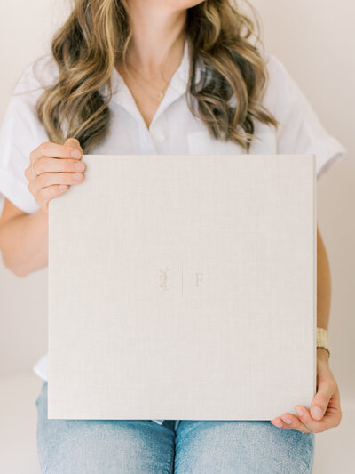Little Rock family photographer Bailey Feeler Photography holding linen matted print box with custom debossing