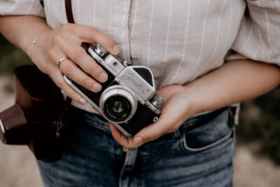 Handen van fotograaf houden oude camera vast