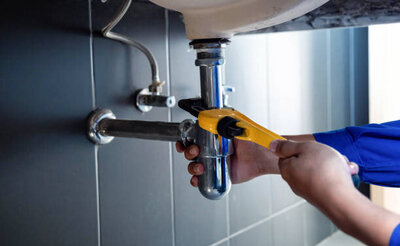 a yellow wrench fixing under sink 