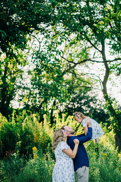 a mom and dad playing with their toddler daughter in a rio, wi family session 