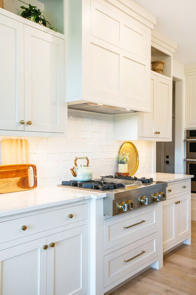 Open-concept kitchen in Minnesota custom home with white cabinetry, large island, and modern finishes built by Minnesota home builders.