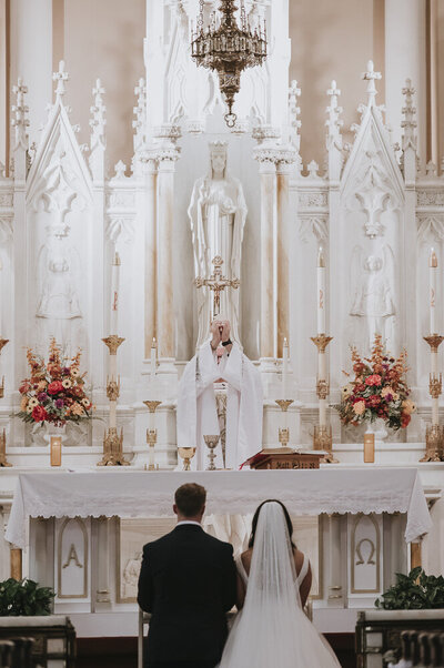 a bride and groom being consecrated at mass