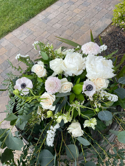 Lush white and green floral arrangement on a stone patio