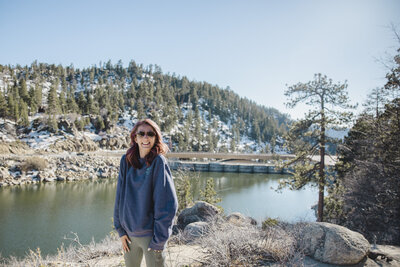 Katie poses in front of a lake on a California trip.