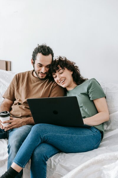 couple sitting together on couch on computer