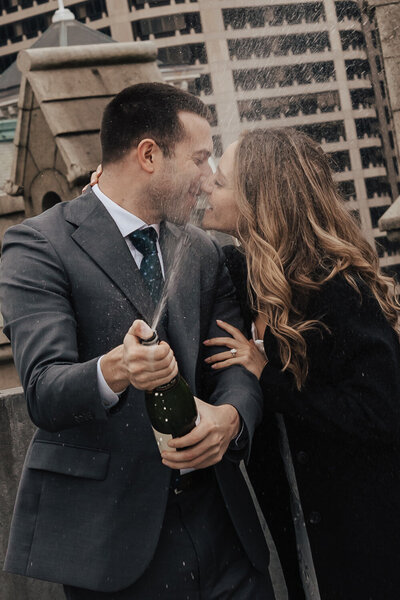 Couple spraying champagne for their wedding on a rooftop in Philadelphia PA