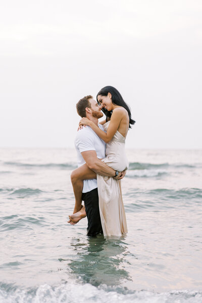 Man holding woman in the lake, engagement photos, cleveland engagement session, lake erie