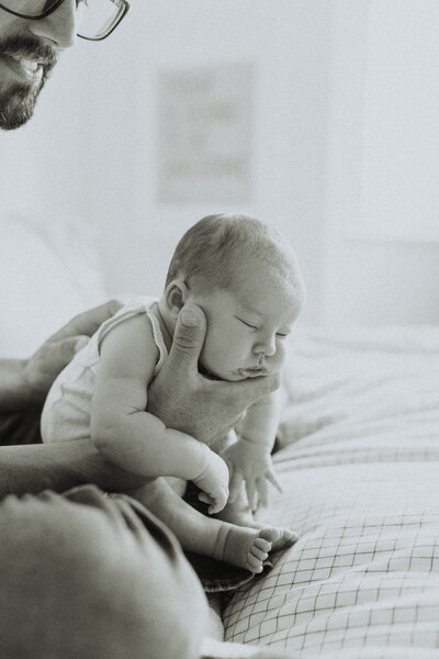 black and white photo of a mom holding her toddler son with them facing each other and their noses touching taken by a langley family & newborn photographer