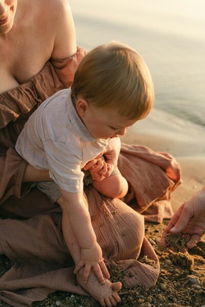 Parent holding baby at sunset captured by a Michigan photographer