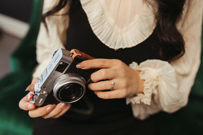 A woman holds a camera in her hands