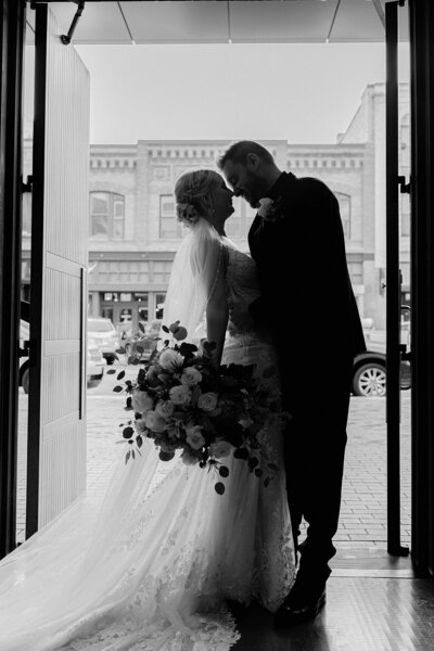 bride and groom about to kiss in a doorway