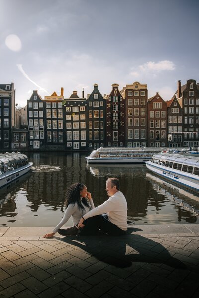 Couple sits along the water in Amsterdam