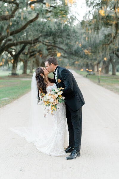 Bride and groom wedding portraits on the avenue of oaks at Boone Hall. Charleston fall wedding.