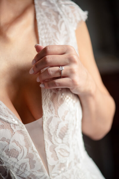 Bride and groom holding hands under a wooden arch during a beachfront wedding ceremony with palm trees and ocean in the background