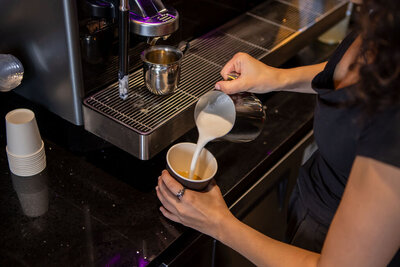 Espresso machine making coffee with steamed milk