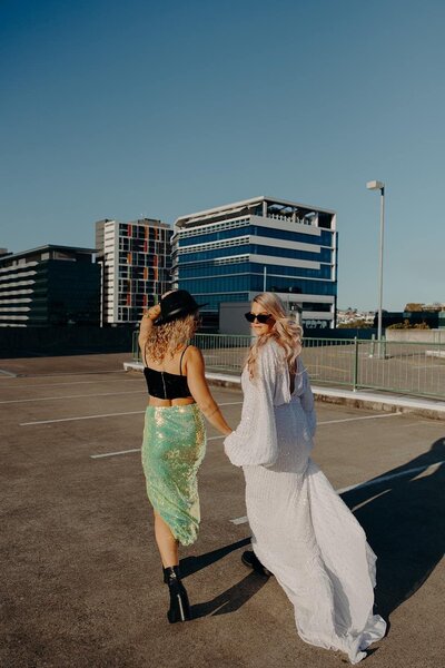 2 Brisbane brides on a rooftop with waves and braid hairstyles