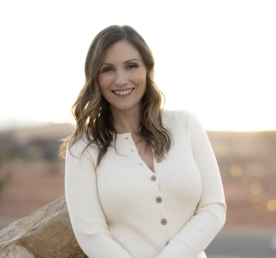 woman in cream smiling at camera